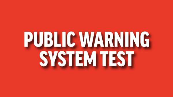 Graphic with a bold red background featuring the white text PUBLIC WARNING SYSTEM TEST in a sans-serif font with a subtle drop shadow. The text is centered and capitalized.